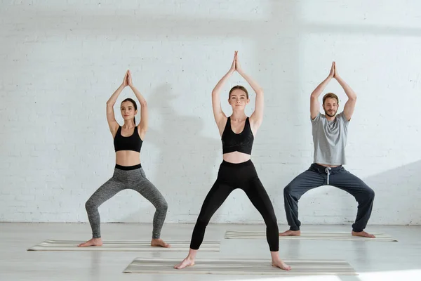 Hombres Mujeres Jóvenes Practicando Yoga Pose Diosa Con Las Manos — Foto de Stock