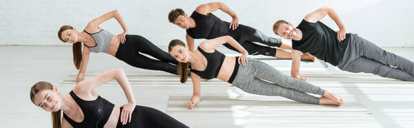 панорамный снимок пяти молодых людей, практикующих йогу в позе боковой доски
