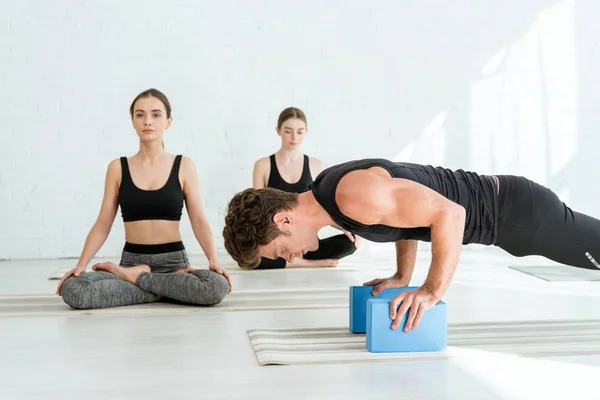 Young Man Practicing Low Push Plank Pose Stands Women Sitting — Stock Photo, Image