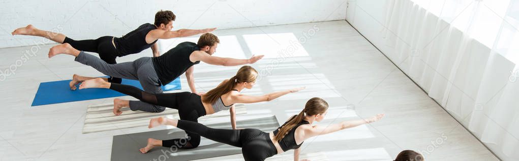 panoramic shot of young people practicing balancing table pose