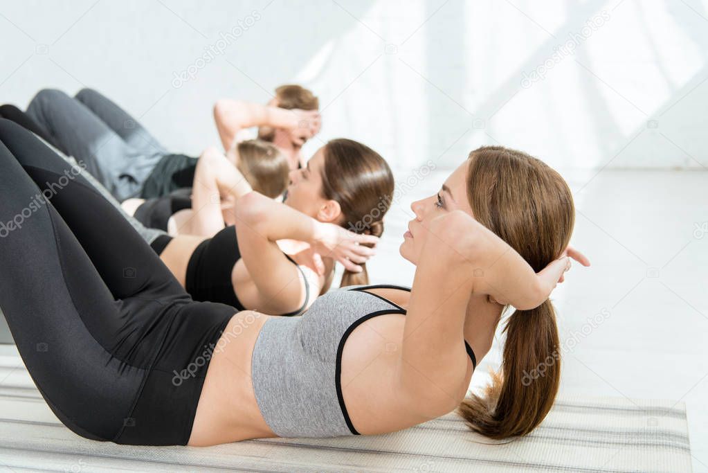 selective focus of attractive girl practicing yoga while doing press ups 
