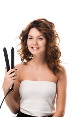 Neşeli ve kıvırcık kız elinde saç düzleştirici tutuyordu. 