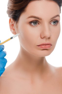 Plastik eldivenli plastik cerrahın çıplak bir hastanın yanında beyaz bir şırınga tutarken çekilmiş görüntüsü. 