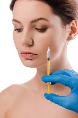 cropped view of plastic surgeon in blue latex glove holding syringe near beautiful naked patient isolated on white  clipart