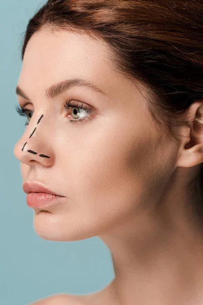 young woman with marked lines on face isolated on blue