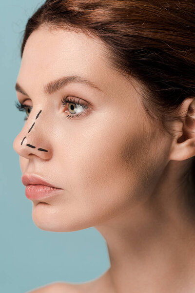 young woman with marked lines on face isolated on blue 