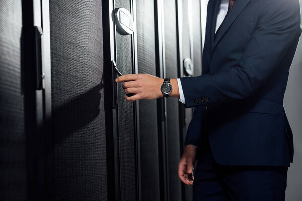 cropped view of businessman in suit standing in data center 