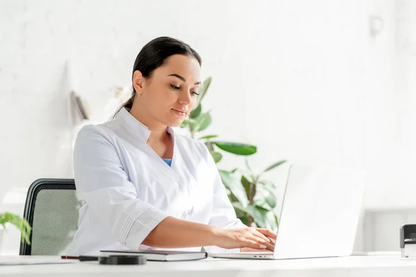 Aantrekkelijke Dermatoloog Zitten Aan Tafel Met Behulp Van Laptop Kliniek — Stockfoto