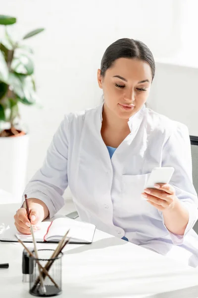 Atractivo Dermatólogo Sentado Mesa Uso Teléfonos Inteligentes Clínica — Foto de Stock