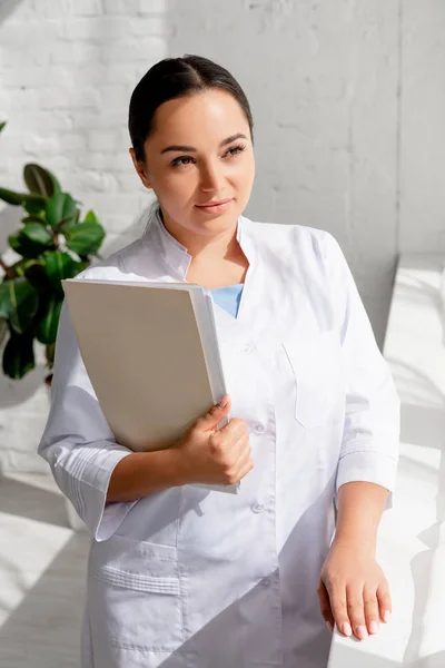 Aantrekkelijke Dermatoloog Holding Map Weg Kijken Kliniek — Stockfoto