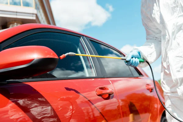 코로나 바이러스가 유행하는 스프레이를 사용하여 차량의 전문가의 모습이 오그라들었다 — 스톡 사진