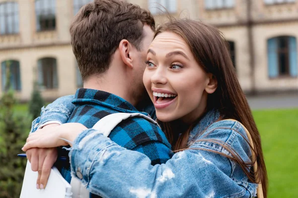 Studente Eccitato Abbracciare Amico Tenere Taccuino Con Penna — Foto Stock