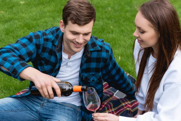 Vrolijk Man Gieten Rode Wijn Buurt Mooi Vriendin Terwijl Het — Stockfoto