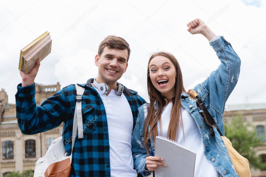 cheerful students celebrating triumph while looking at camera 