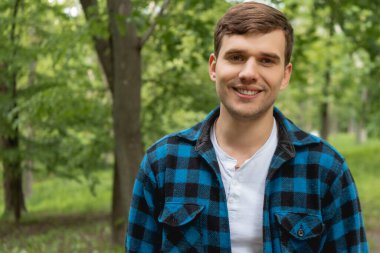 Yeşil Park 'taki kameraya bakan neşeli genç adam. 