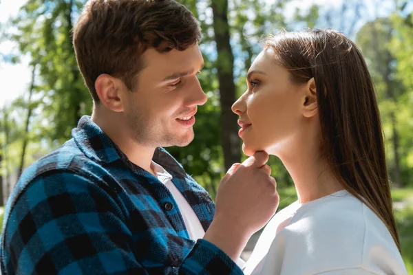 Boční Pohled Šťastný Muž Dotýká Tvář Atraktivní Přítelkyně Parku — Stock fotografie