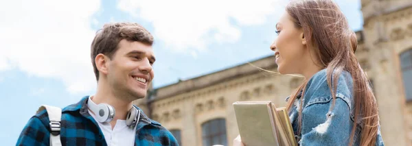 Plano Panorámico Chica Alegre Sosteniendo Libros Hablando Con Estudiante Feliz — Foto de Stock