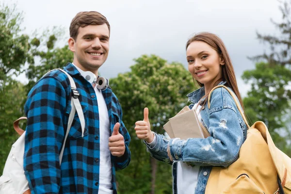 Radośni Studenci Patrzący Kamerę Pokazujący Kciuki Góry — Zdjęcie stockowe