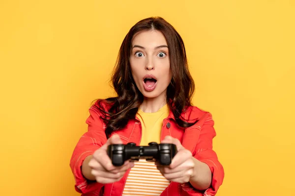 Kyiv Ukraine 2020年5月25日 黄色に隔離されたビデオゲームをプレイしながらジョイスティックを保持驚きの若い女性の選択的な焦点 — ストック写真