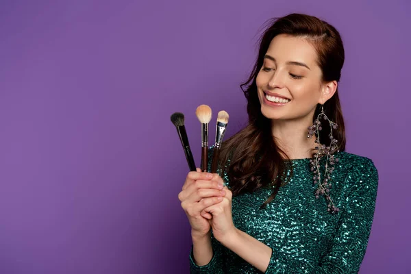 Mutlu Kadın Mor Üzerindeki Kozmetik Fırçalara Bakıyor — Stok fotoğraf