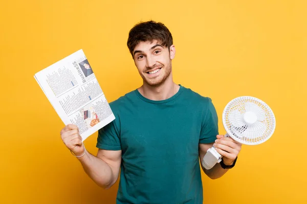 Jovem Feliz Segurando Jornal Ventilador Elétrico Amarelo — Fotografia de Stock