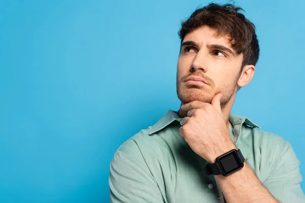 Thoughtful Young Man Looking Away While Touching Chin Blue — Stock Photo, Image