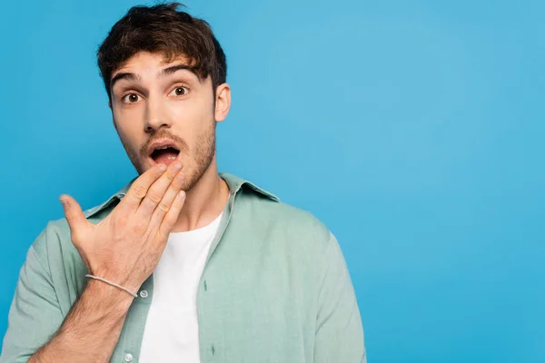 Geschokte Jongeman Kijken Naar Camera Geïsoleerd Blauw — Stockfoto