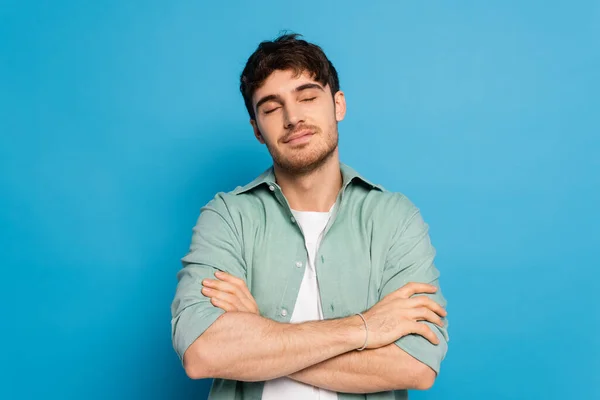 Dromerige Man Met Gesloten Ogen Staande Met Gekruiste Armen Blauw — Stockfoto