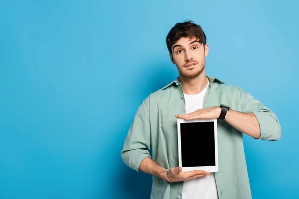 Pohledný Mladý Muž Ukazuje Digitální Tablet Prázdnou Obrazovkou Modré — Stock fotografie