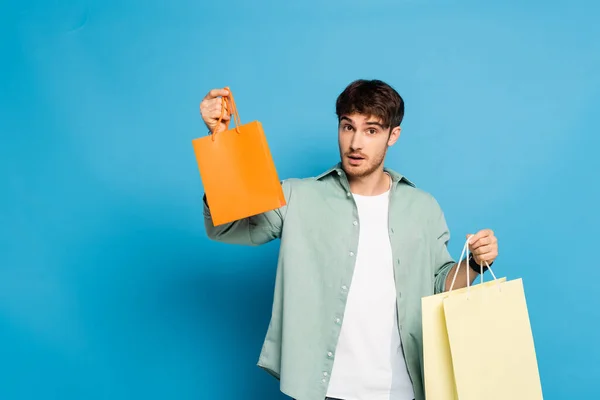 Handsome Young Man Showing Shopping Bags Blue — Stock Photo, Image