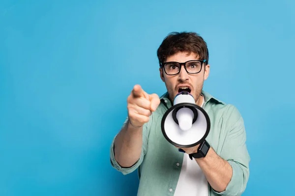 Aggressive Young Man Screaming Megaphone Pointing Finger Blue — Stock Photo, Image