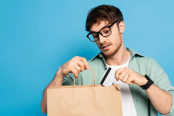 Handsome Young Man Putting Credit Card Shopping Bag Blue — Stock Photo, Image