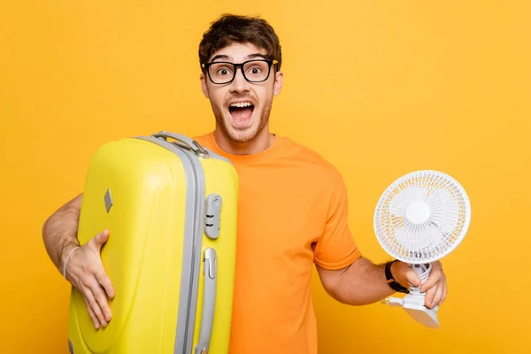 Excited Man Holding Travel Bag Electric Fan Yellow — Stock Photo, Image