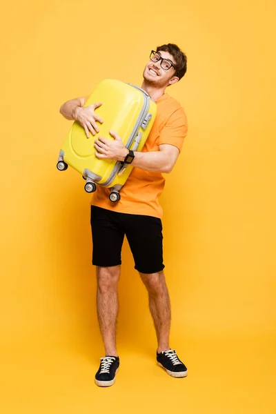 Sonriente Turista Masculino Sosteniendo Maleta Para Vacaciones Verano Amarillo — Foto de Stock