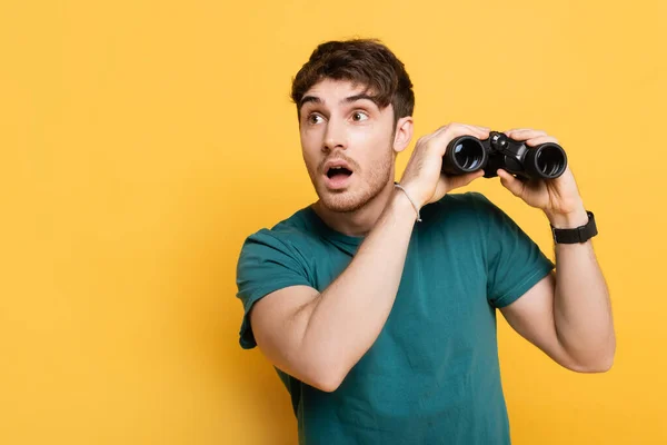 Handsome Shocked Man Holding Binoculars Yellow — Stock Photo, Image