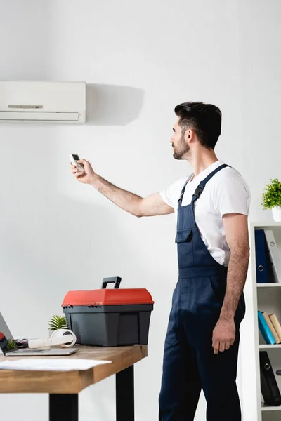 Reparateur Mit Klimaanlage Fernbedienung Während Der Nähe Von Werkzeugkasten Steht — Stockfoto