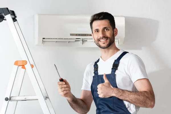 Happy Repairman Showing Thumb Holding Screwdriver While Standing Stepladder Air — Stock Photo, Image