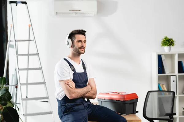 Workman Wireless Headphones Sitting Desk Crossed Arms Toolbox Air Conditioner — Stock Photo, Image