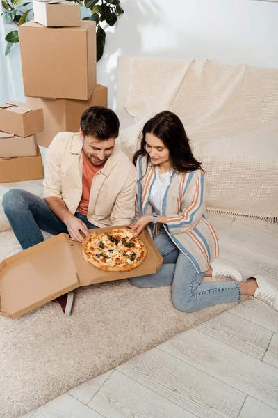 Sorrindo Homem Segurando Pedaço Pizza Perto Namorada Casa Nova — Fotografia de Stock