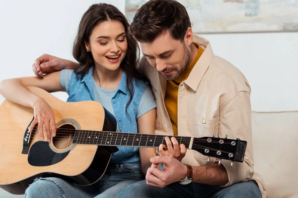 Adam Akustik Gitar Çalarken Gülümseyen Kız Arkadaşını Kucaklıyor — Stok fotoğraf