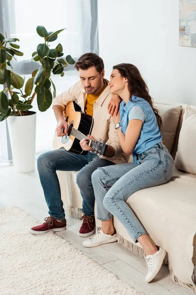 Souriante Fille Regardant Son Petit Ami Jouer Guitare Acoustique Maison — Photo