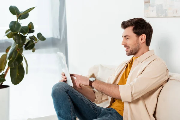 Hombre Sonriente Sentado Sofá Usando Tableta Digital Sala Estar — Foto de Stock