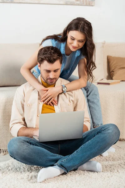 Smiling Woman Hugging Boyfriend Using Laptop Home — Stock Photo, Image