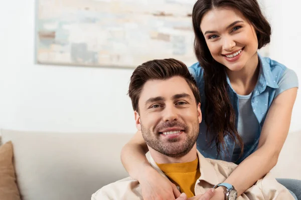 Mulher Bonita Sorrindo Para Câmera Enquanto Abraça Namorado Casa — Fotografia de Stock