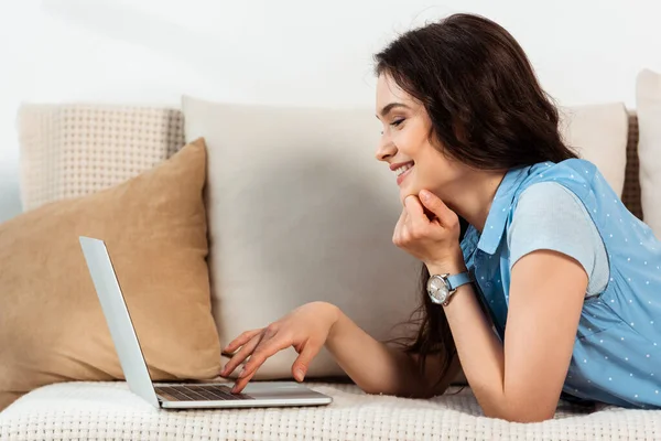 Sidovy Leende Flicka Med Hjälp Laptop När Ligger Soffan Hemma — Stockfoto