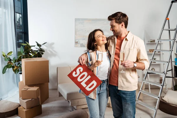 Positive Couple Holding Glasses Champagne Nameplate Sold Lettering Living Room — Stock Photo, Image