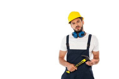 Üniformalı yakışıklı işçi ve çekiç tutan kasklı beyaz kameraya bakıyor.