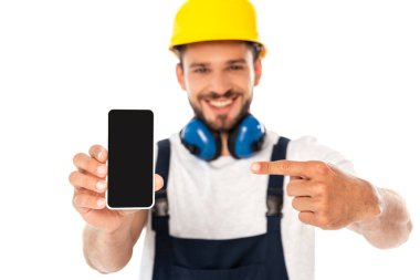 Beyaz ekranı boş olan akıllı telefonu işaret eden gülümseyen tamircinin seçici odağı