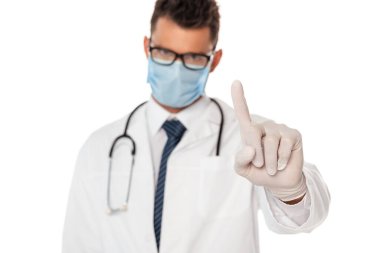 Koruyucu maskeli ve gözlüklü doktorun seçici odak noktası beyaz üzerine izole edilmiş parmak ile gösteriliyor