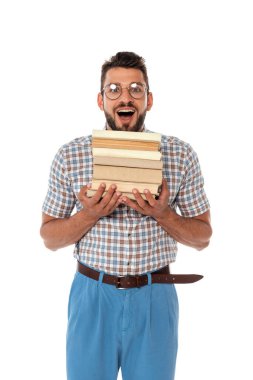 Cheerful nerd holding books and looking at camera isolated on white clipart